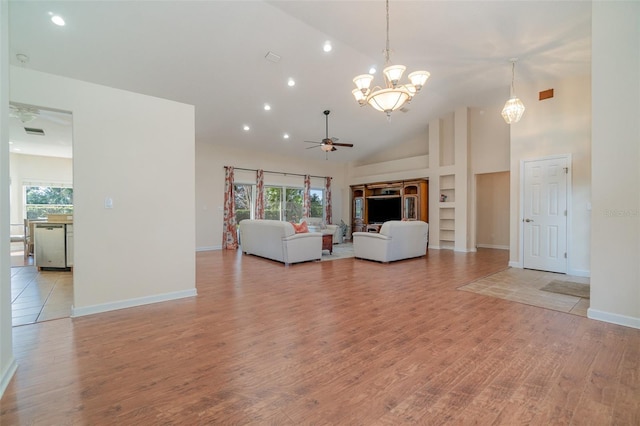 unfurnished living room featuring high vaulted ceiling, ceiling fan with notable chandelier, and light hardwood / wood-style flooring