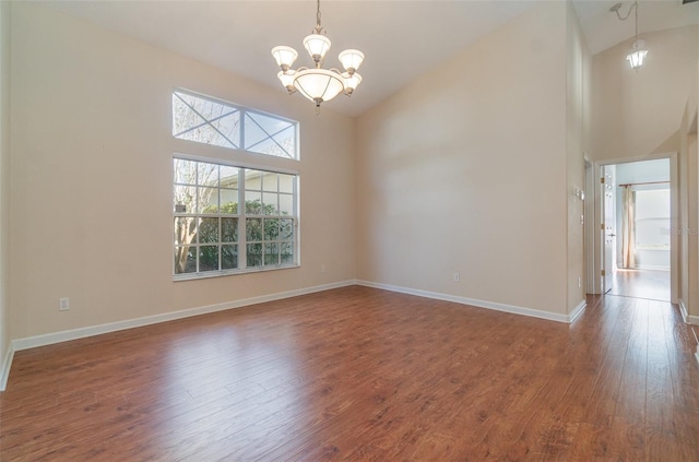 unfurnished room with wood-type flooring, a chandelier, and high vaulted ceiling