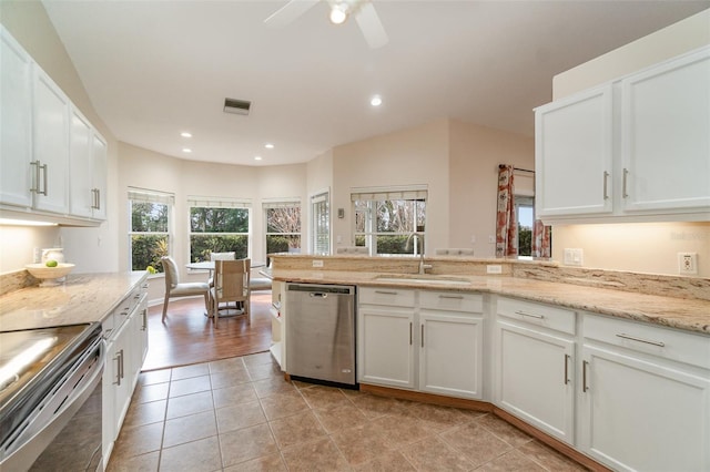 kitchen with appliances with stainless steel finishes, sink, white cabinets, and light stone counters