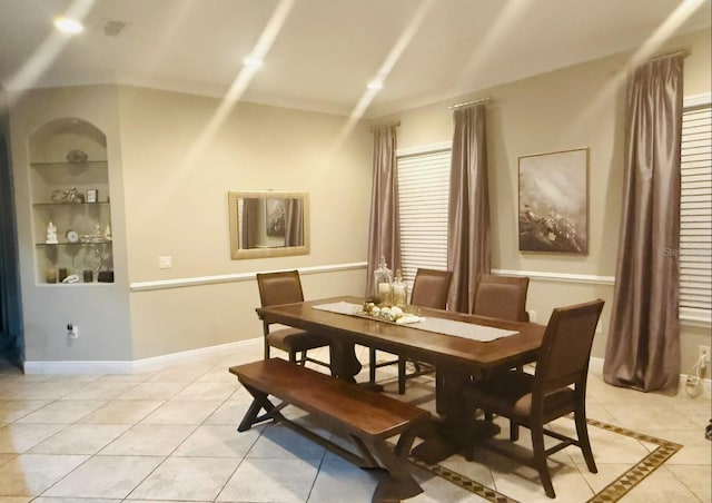 dining space featuring built in shelves and light tile patterned flooring