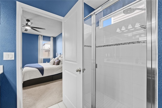 bathroom with ceiling fan, tile patterned flooring, and a shower with door