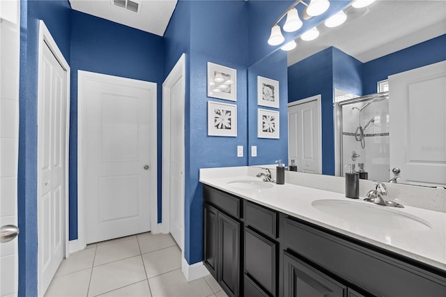 bathroom featuring walk in shower, vanity, and tile patterned flooring