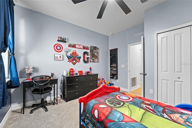 bedroom with ceiling fan, light carpet, and a closet