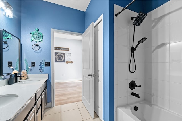 bathroom featuring tile patterned flooring, tiled shower / bath, and vanity