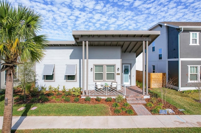 view of front facade featuring a front yard and covered porch