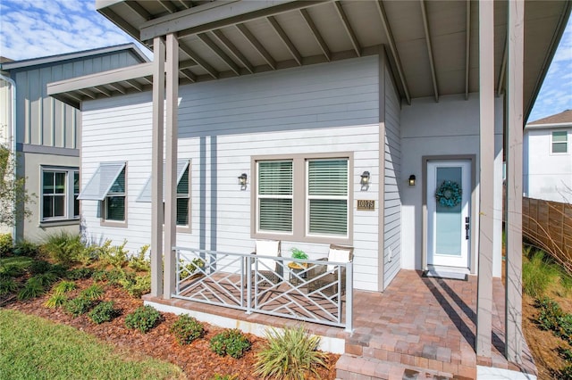 view of exterior entry featuring covered porch