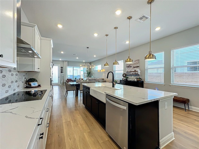 kitchen featuring decorative light fixtures, white cabinetry, dishwasher, black electric stovetop, and a center island with sink