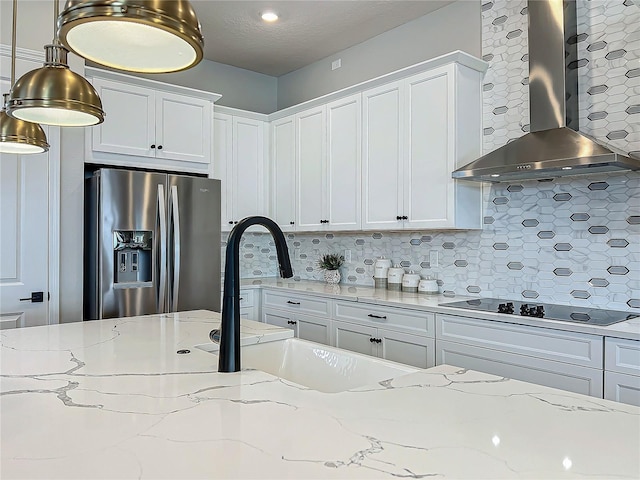 kitchen with white cabinetry, wall chimney range hood, backsplash, and stainless steel fridge with ice dispenser