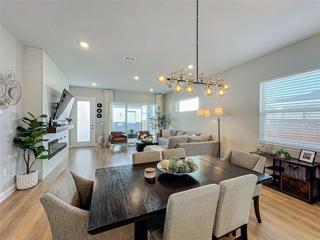 dining room with light hardwood / wood-style flooring and a textured ceiling