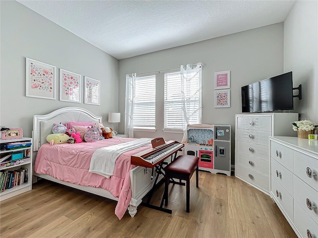 bedroom with a textured ceiling and light wood-type flooring