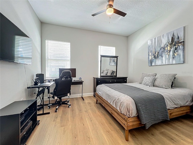 bedroom featuring multiple windows, ceiling fan, and light hardwood / wood-style flooring