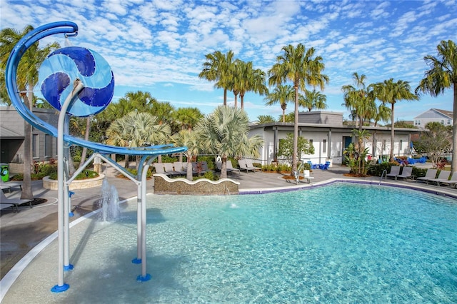 view of pool featuring pool water feature, a water slide, and a patio area