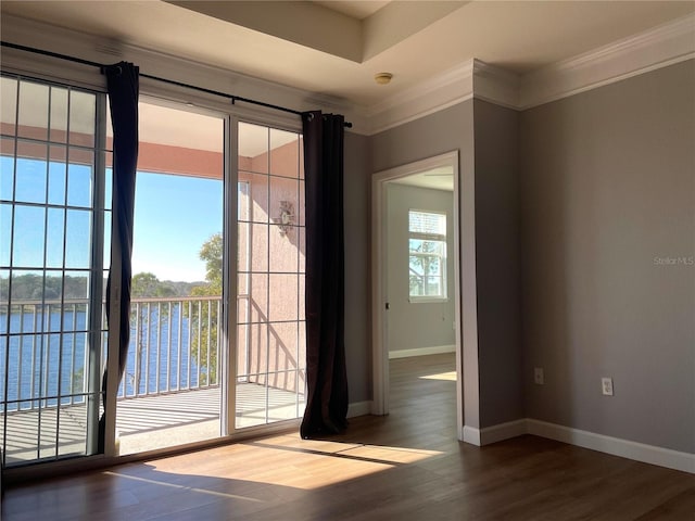 doorway to outside featuring dark wood-type flooring, ornamental molding, and a water view