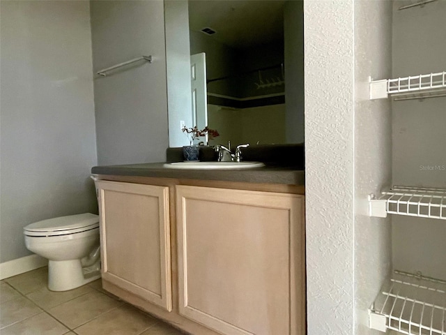 bathroom featuring vanity, toilet, and tile patterned flooring