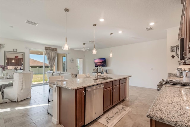 kitchen featuring pendant lighting, stainless steel appliances, and an island with sink