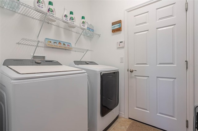 laundry room with independent washer and dryer and light tile patterned flooring