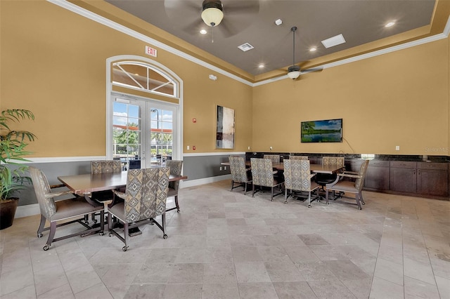 dining room with a high ceiling, crown molding, ceiling fan, and french doors