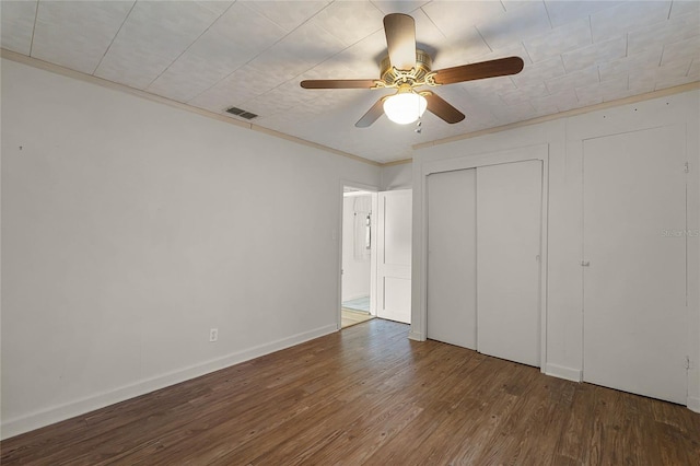 unfurnished bedroom with ceiling fan, ornamental molding, dark hardwood / wood-style floors, and a closet