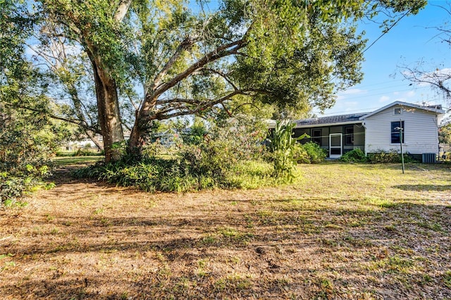 view of yard with central AC and a sunroom