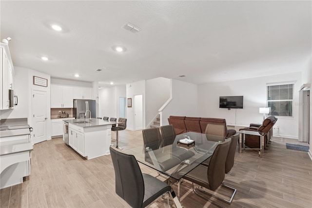 dining space featuring sink and light wood-type flooring