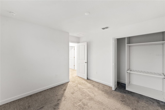 unfurnished bedroom with carpet flooring and a closet