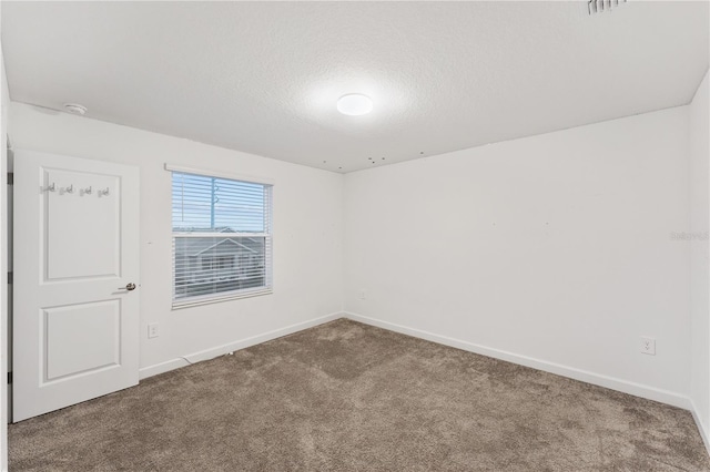 carpeted spare room featuring a textured ceiling