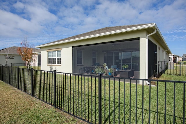 back of property with a lawn and a sunroom