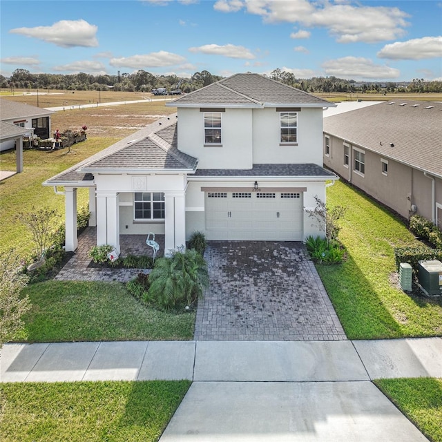 view of front of house featuring central AC, a garage, and a front yard