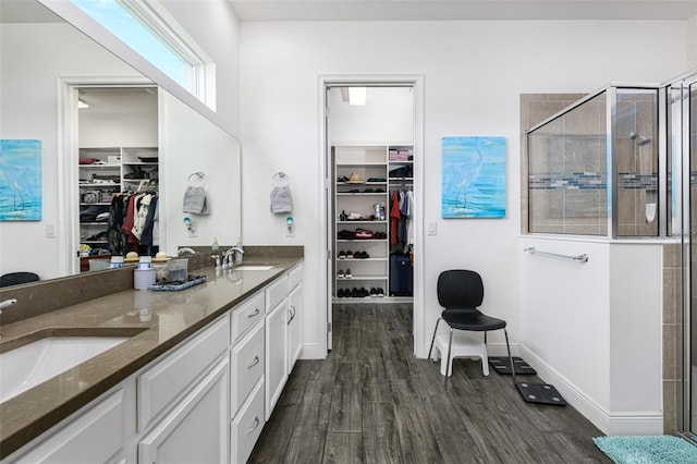 bathroom with vanity, wood-type flooring, and a shower with door