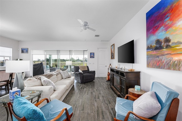 living room featuring dark wood-type flooring and ceiling fan