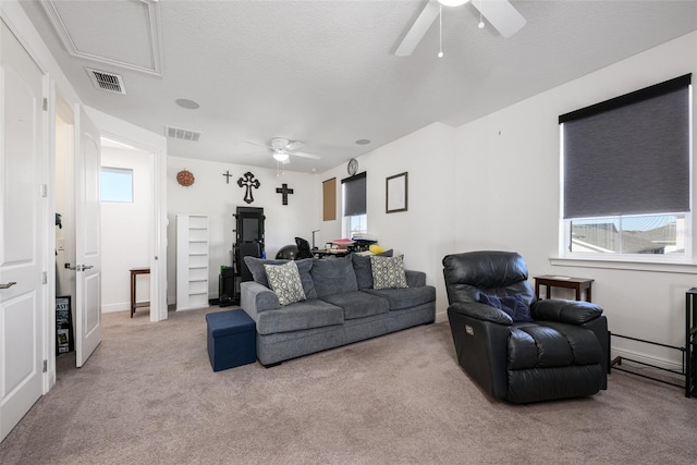 carpeted living room featuring a textured ceiling and ceiling fan