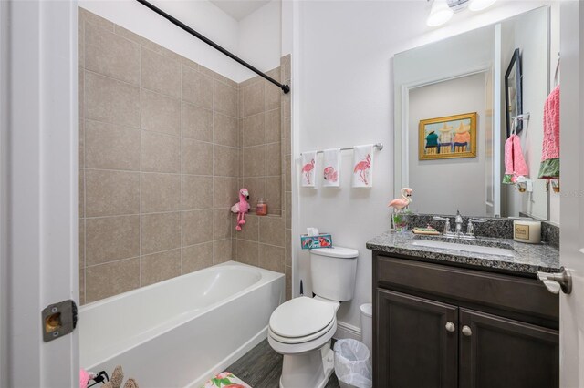 full bathroom with hardwood / wood-style floors, vanity, toilet, and tiled shower / bath