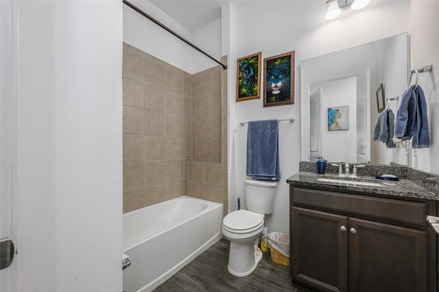 full bathroom with vanity, hardwood / wood-style floors, tiled shower / bath combo, and toilet