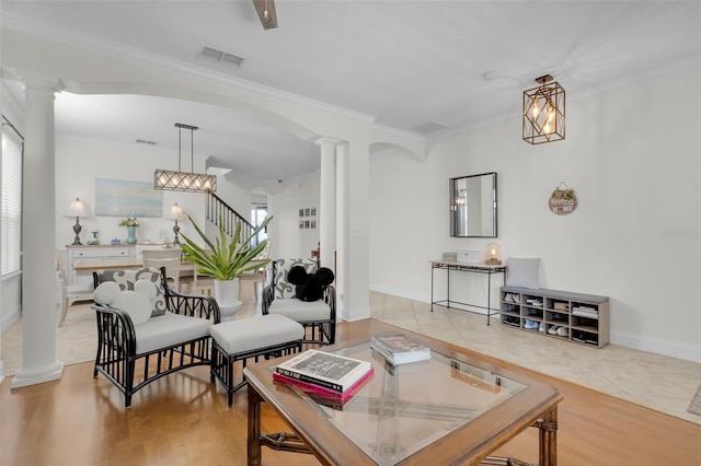 living room featuring ornamental molding, decorative columns, and light hardwood / wood-style floors