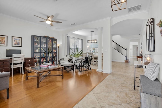 living room with light tile patterned floors, ornamental molding, and decorative columns