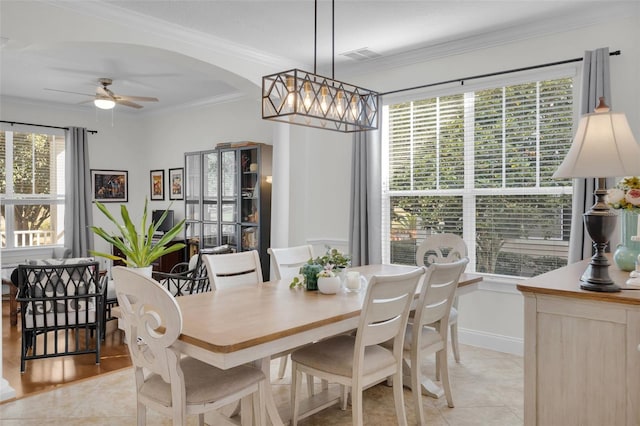 dining room with crown molding, light tile patterned floors, and ceiling fan