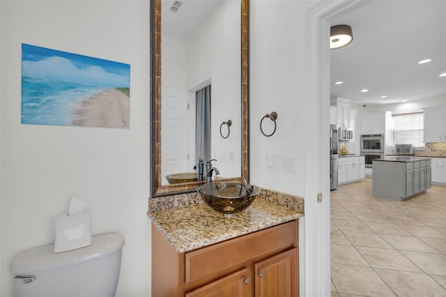 bathroom with vanity, toilet, and tile patterned flooring