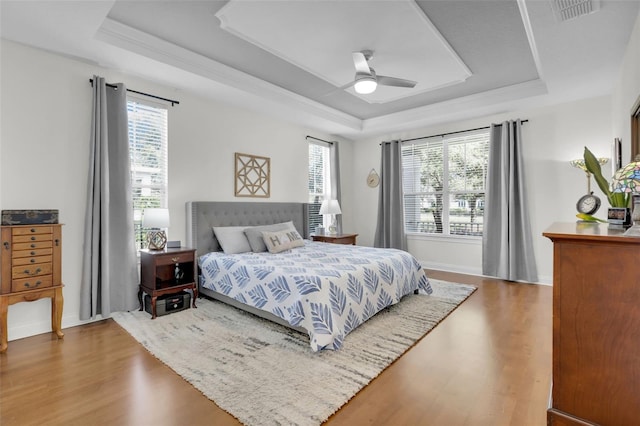 bedroom featuring a tray ceiling, ceiling fan, and hardwood / wood-style flooring