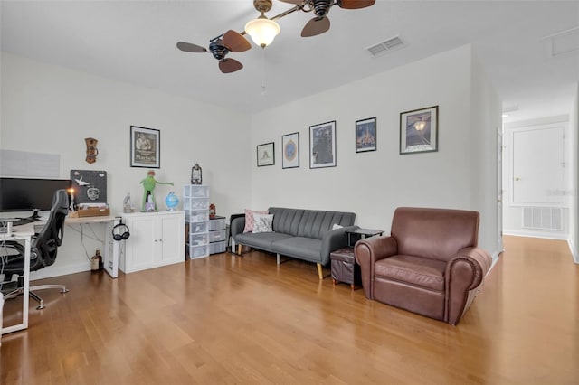 living room featuring ceiling fan and light hardwood / wood-style flooring