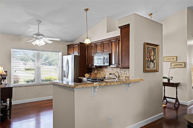 kitchen featuring pendant lighting, a kitchen breakfast bar, stainless steel appliances, light stone countertops, and kitchen peninsula