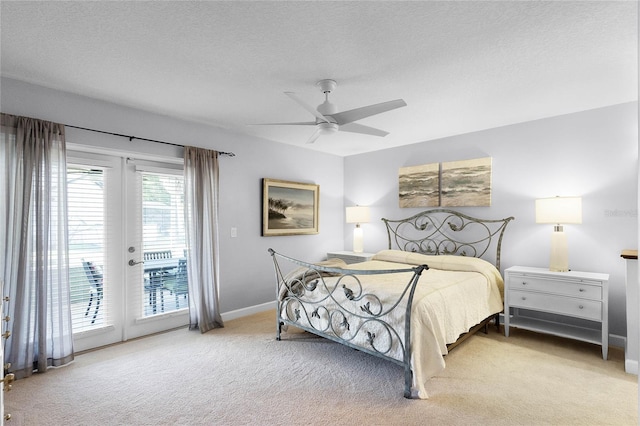 carpeted bedroom with french doors, ceiling fan, access to exterior, and a textured ceiling