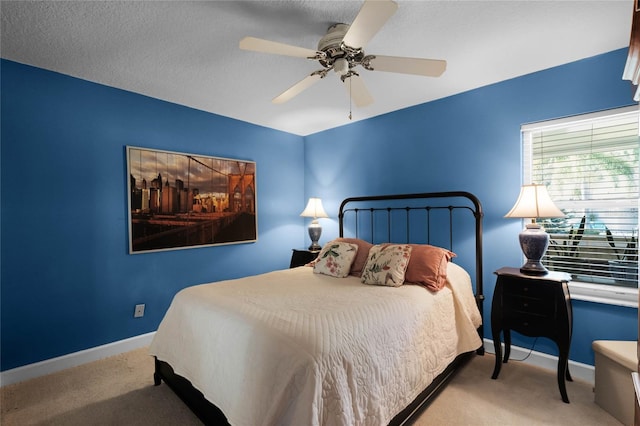 bedroom featuring light carpet, a textured ceiling, and ceiling fan