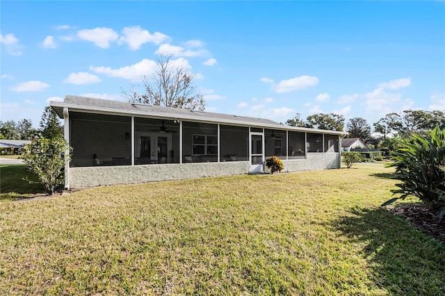 back of property with a sunroom and a lawn