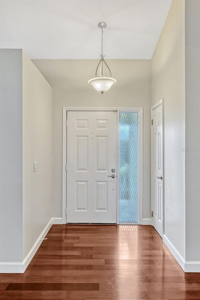 entryway featuring baseboards and wood finished floors