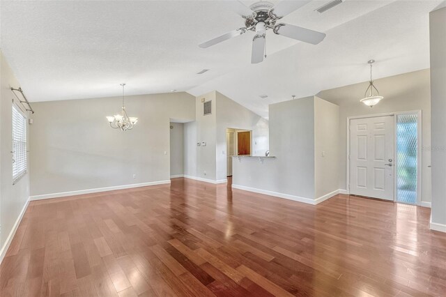 unfurnished living room featuring baseboards, ceiling fan with notable chandelier, wood finished floors, and visible vents
