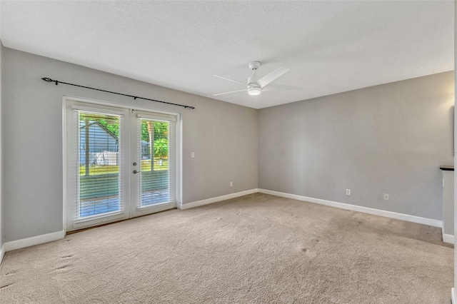 spare room featuring baseboards, light carpet, and french doors