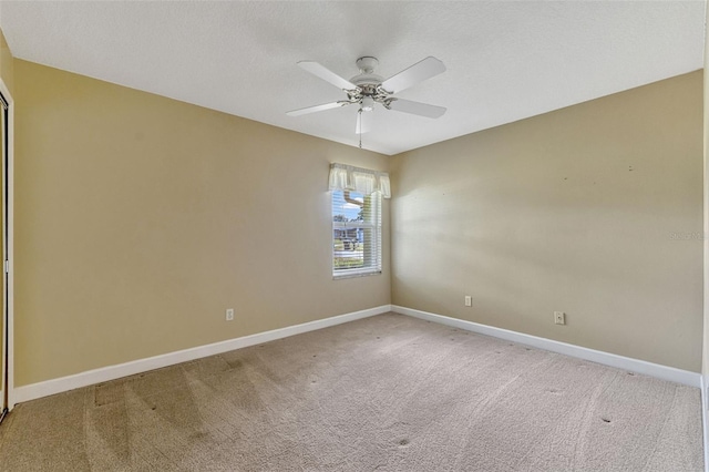 spare room featuring baseboards, carpet flooring, and a ceiling fan
