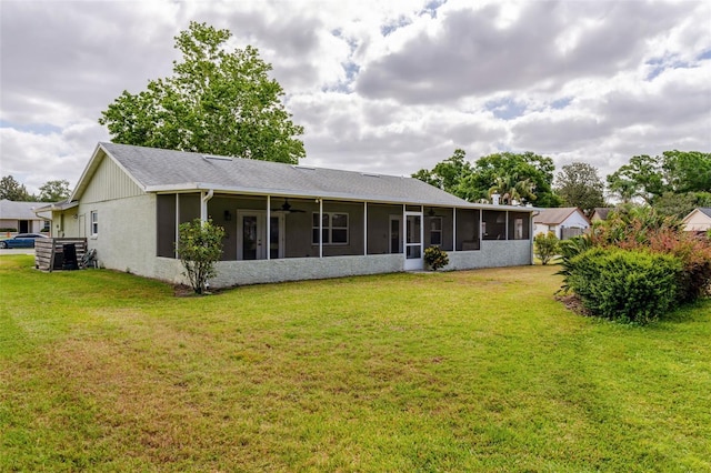 back of property with a yard, ceiling fan, and a sunroom