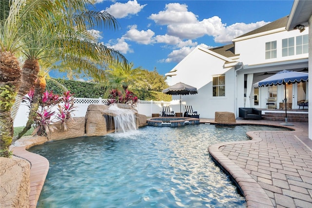 view of pool with an in ground hot tub, pool water feature, and a patio