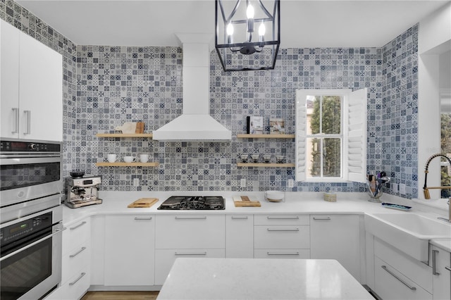 kitchen featuring white cabinetry, stainless steel double oven, black gas cooktop, and sink